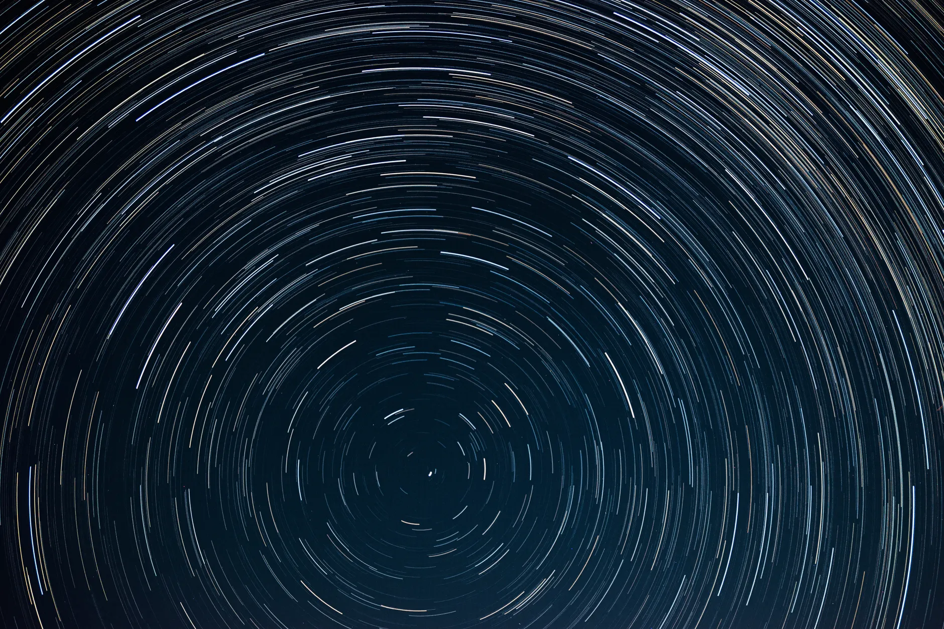 Vista hipnotizante de trilhas de estrelas circulares contra um profundo céu noturno, capturada em longa exposição.