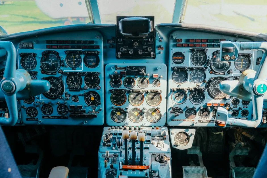 Vista em close do cockpit de uma aeronave vintage, destacando painéis de controle e instrumentos detalhados.