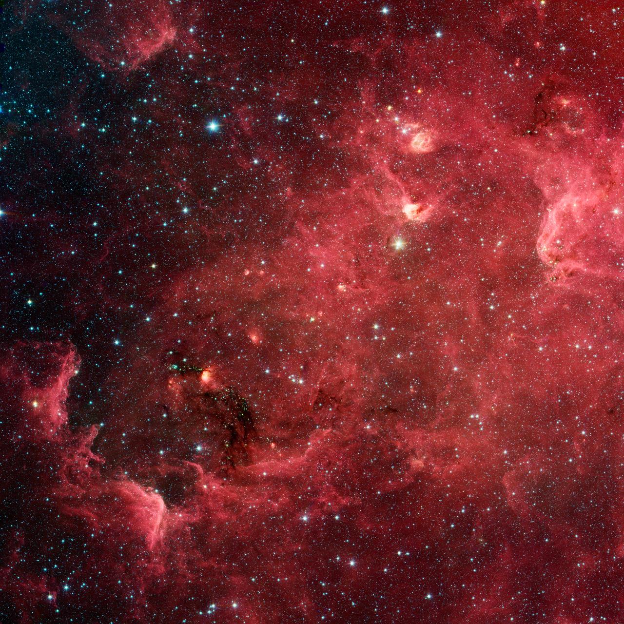 This infrared image from NASA Spitzer Space Telescope shows a swirling landscape of stars known as the North America nebula. Clusters of young stars about one million years old can be found throughout the image.