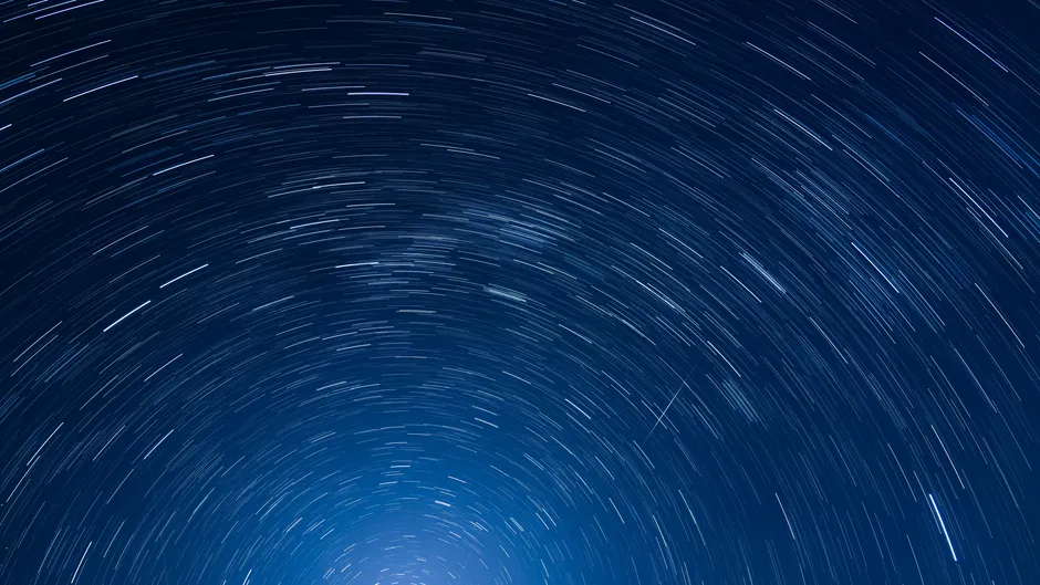 Fotografia de longa exposição capturando rastros de estrelas hipnotizantes que criam padrões circulares no céu noturno de Sydney, Austrália.