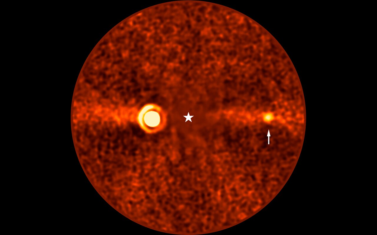 Imagem processada do sistema Beta Pictoris mostrando a posição do planeta Beta Pictoris d perto da estrela.