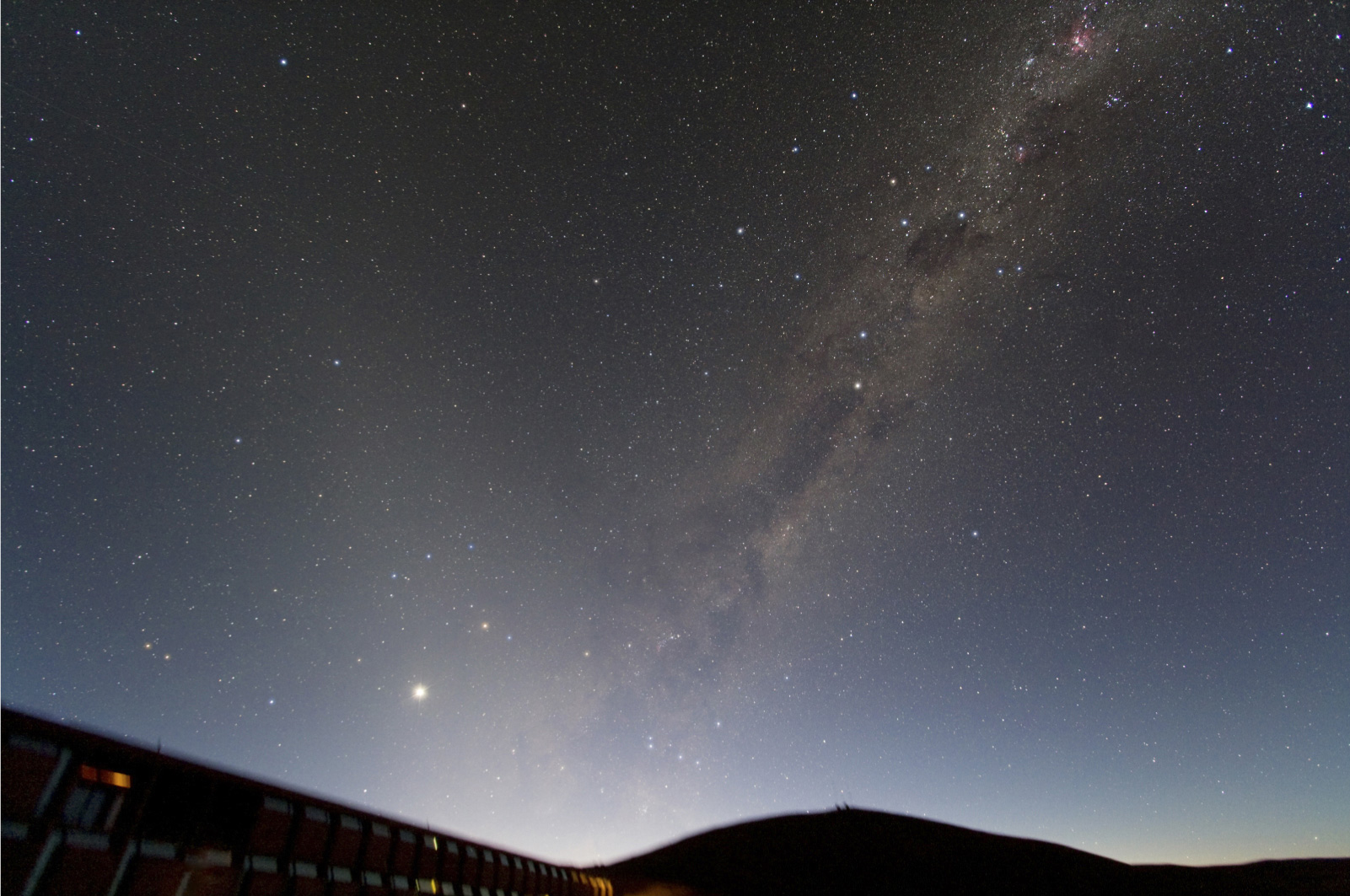 Photo of the morning sky above the Paranal Residencia taken by ESO astronomer Yuri Beletsky. The Milky Way is nicely seen along with its numerous dark dust lanes and amazing nebulae. The Zodiacal light - sunlight reflected by interplanetary dust - is clearly visible as the band of light that is inclined with respect to the Milky Way by about 40-50 degrees. The planet Venus is also visible in this photo, just above the Residencia.