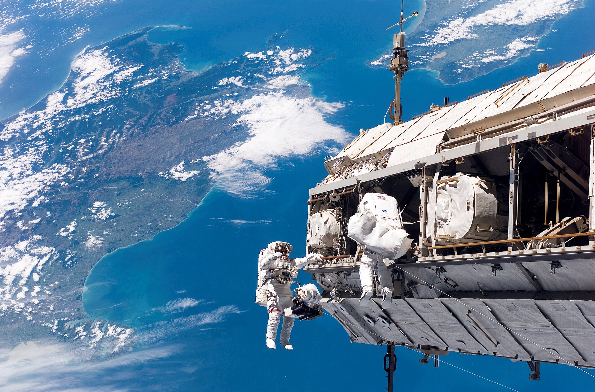 STS-116 Shuttle Mission Imagery Backdropped by a colorful Earth, NASA astronaut Robert L. Curbeam, Jr. (left) and European Space Agency (ESA) astronaut Christer Fuglesang, both STS-116 mission specialists, participate in the mission's first of three planned sessions of extravehicular activity (EVA) as construction resumes on the International Space Station. The landmasses depicted are the South Island (left) and North Island (right) of New Zealand. Explanation: The International Space Station (I