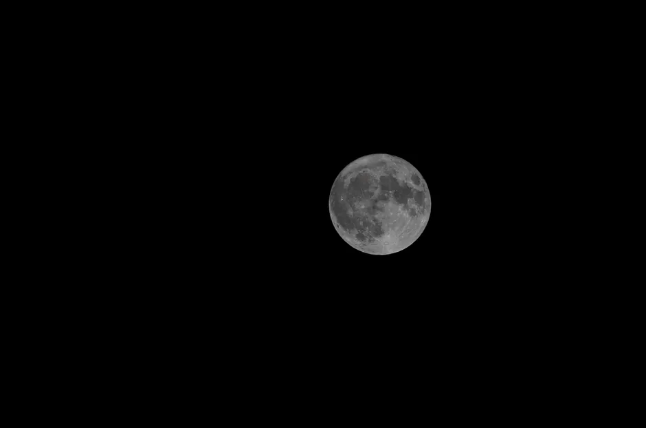 Uma fotografia detalhada da lua cheia no céu noturno claro, observada de Israel.