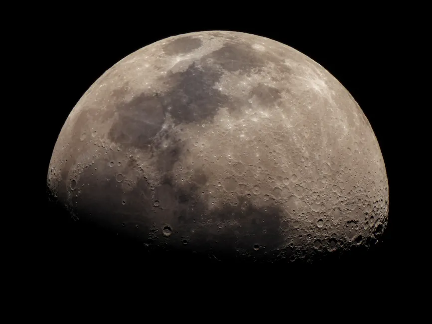 Um close detalhado da lua mostrando suas crateras e textura da superfície.