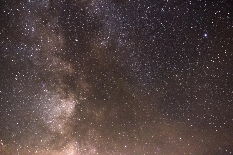 Linda vista da galáxia Via Láctea se estendendo pelo céu estrelado, destacando maravilhas cósmicas.