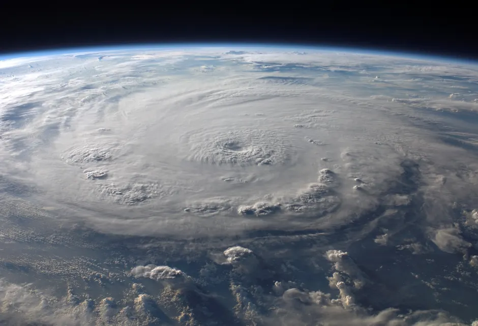 Uma impressionante vista aérea da Terra com um imenso furacão em espiral, destacando a beleza meteorológica.