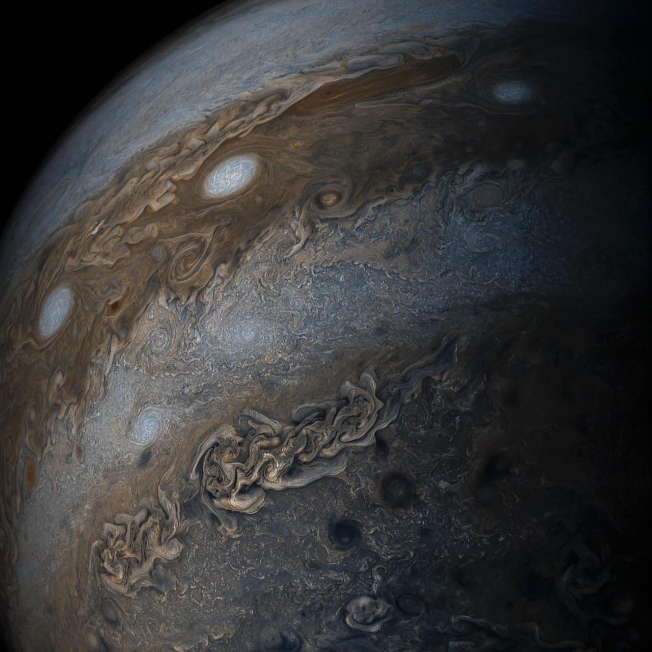 Three of the white oval storms known as the "String of Pearls" are visible near the top of the image.
